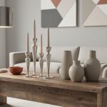 “Contemporary living room accessories arranged on a reclaimed wood console with brushed-metal lighting, ceramic vases, and geometric wall art in soft natural daylight.”
